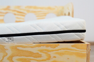 Materac piankowy na drewnianym łóżku